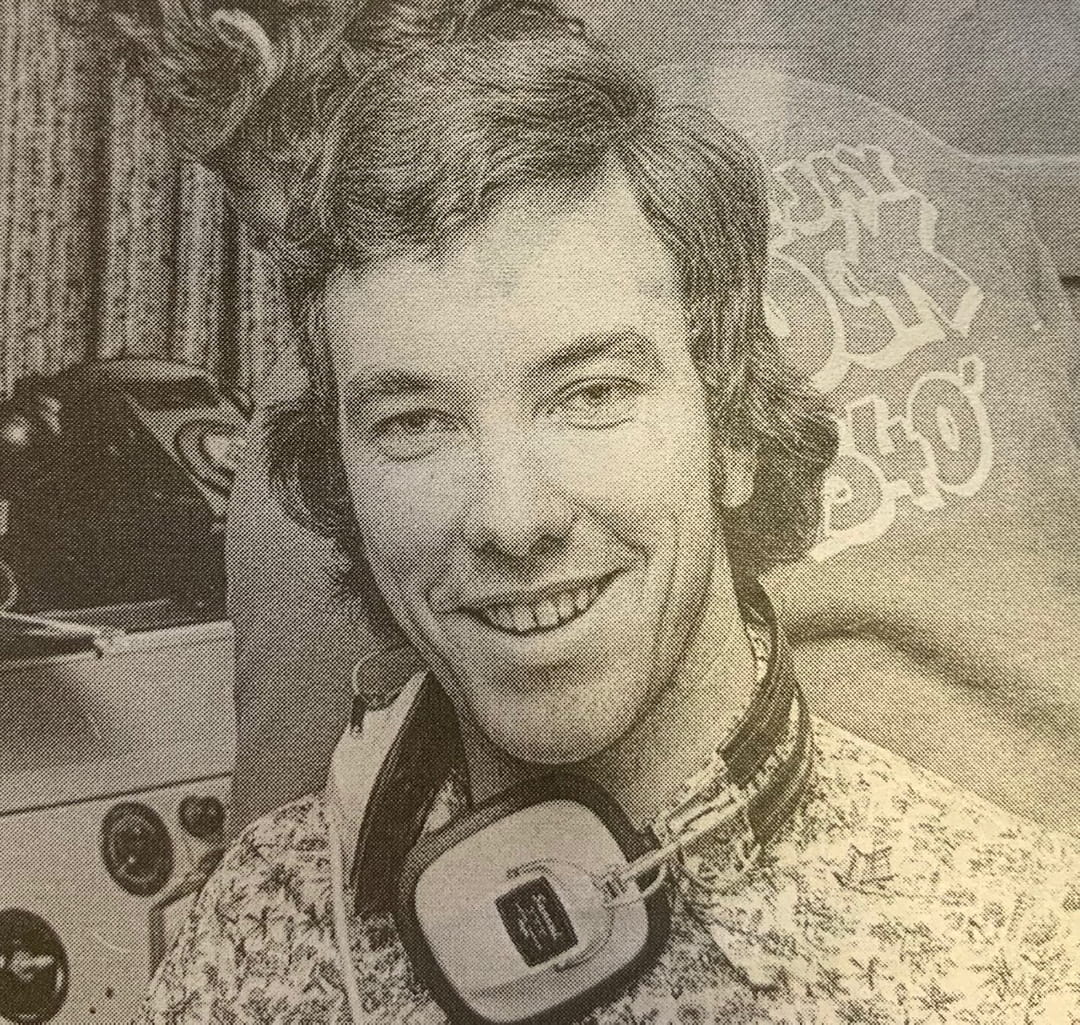 black and white aged photo man with headphones around neck
