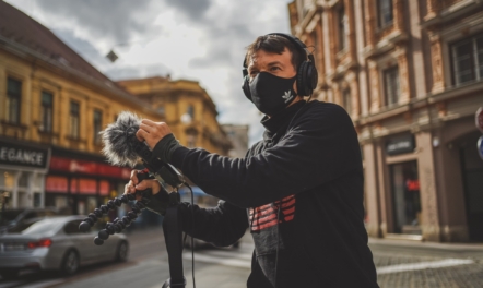 man in mask outdoors with mic