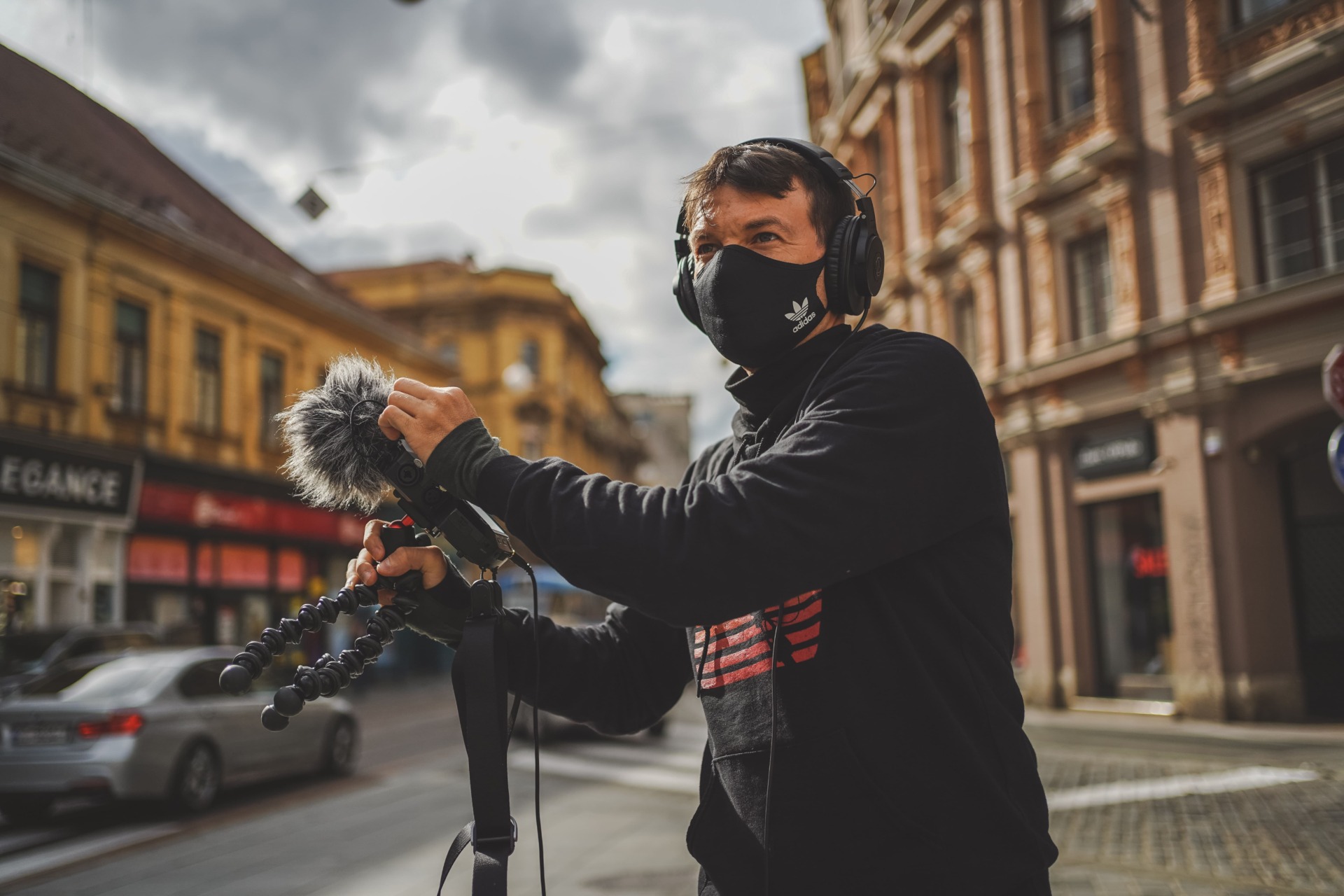 man in mask outdoors with mic